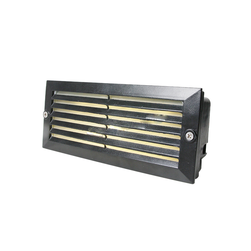 Close-up of a sleek LED step light on a stone staircase.