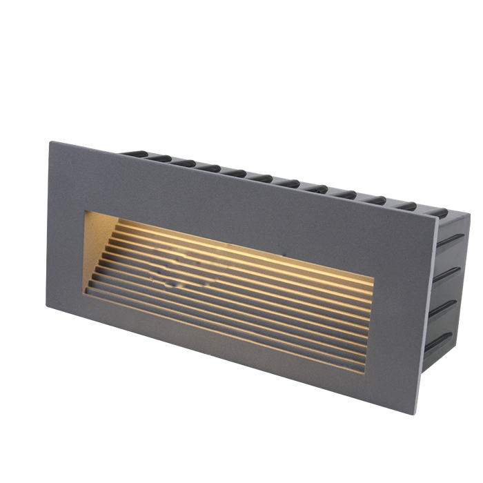 A row of small, round step lights embedded along the edge of outdoor concrete stairs, glowing softly in the evening.